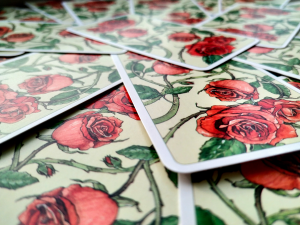 Deck of tarot cards with red roses across the back